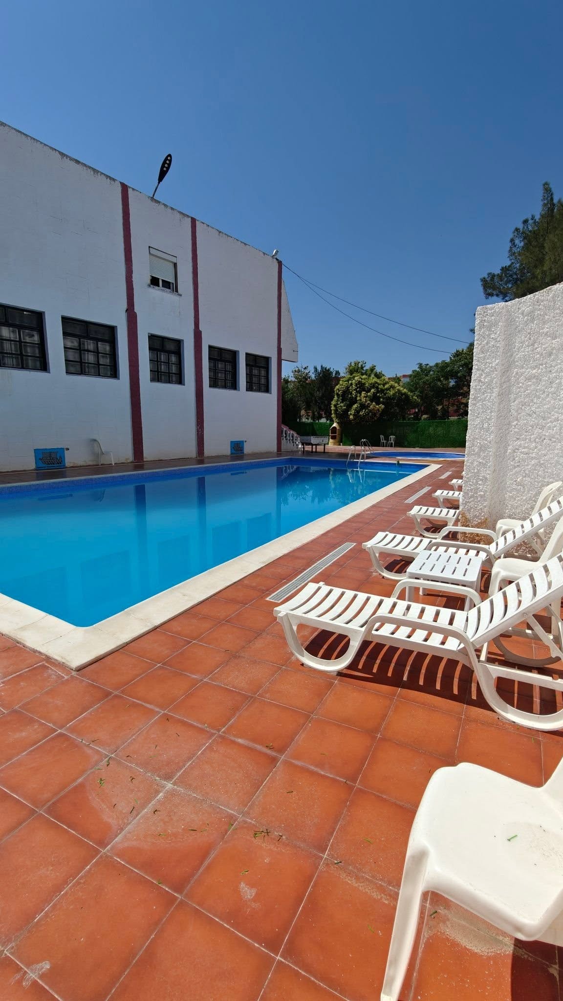 Outdoor swimming pool with sun loungers at Hôtel Phinicia